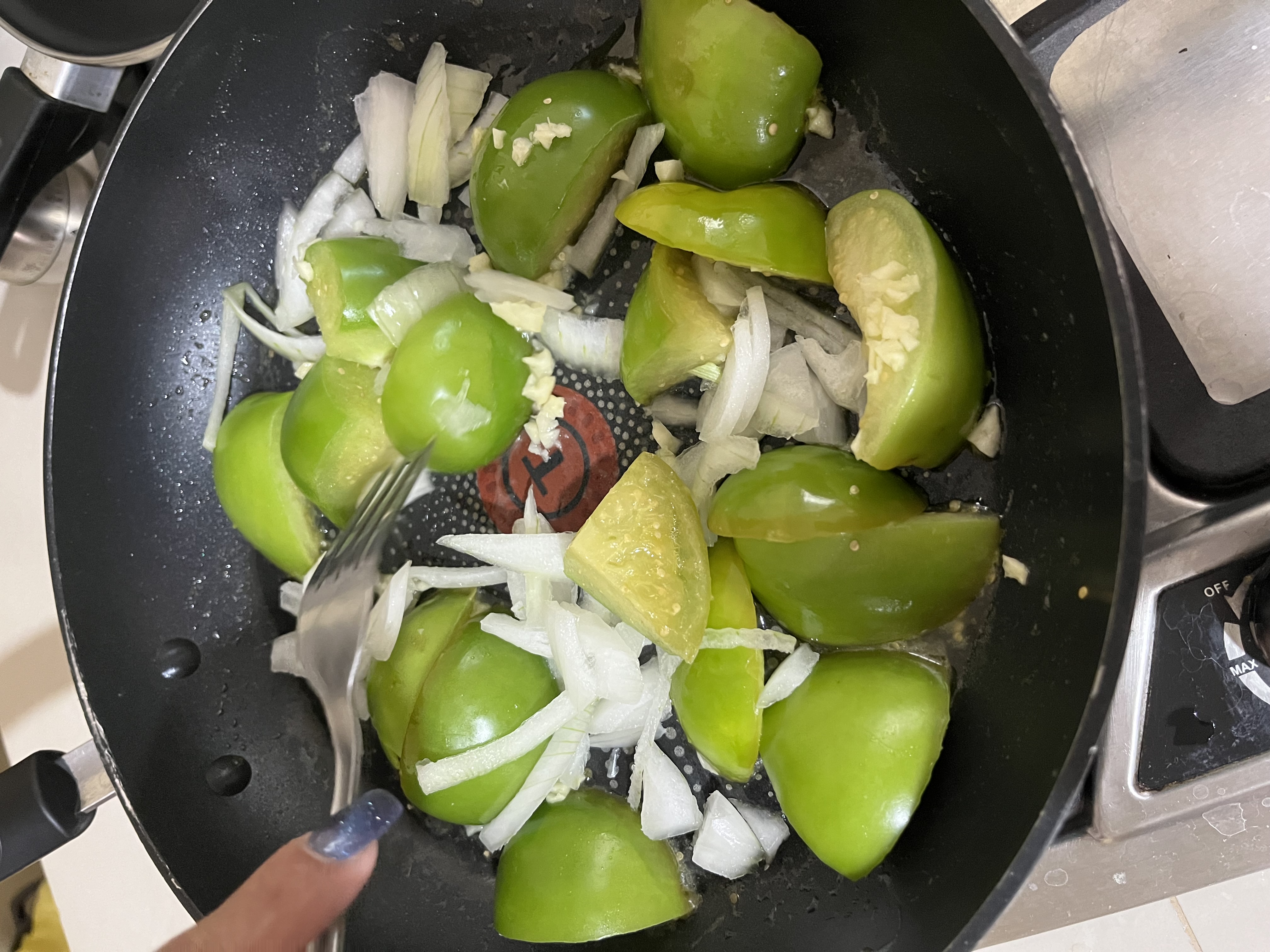 Tomatoes cooking with onion and garlic The half onion and garlic clove have now been chopped and added to the pan with the tomatoes. We're making progress!