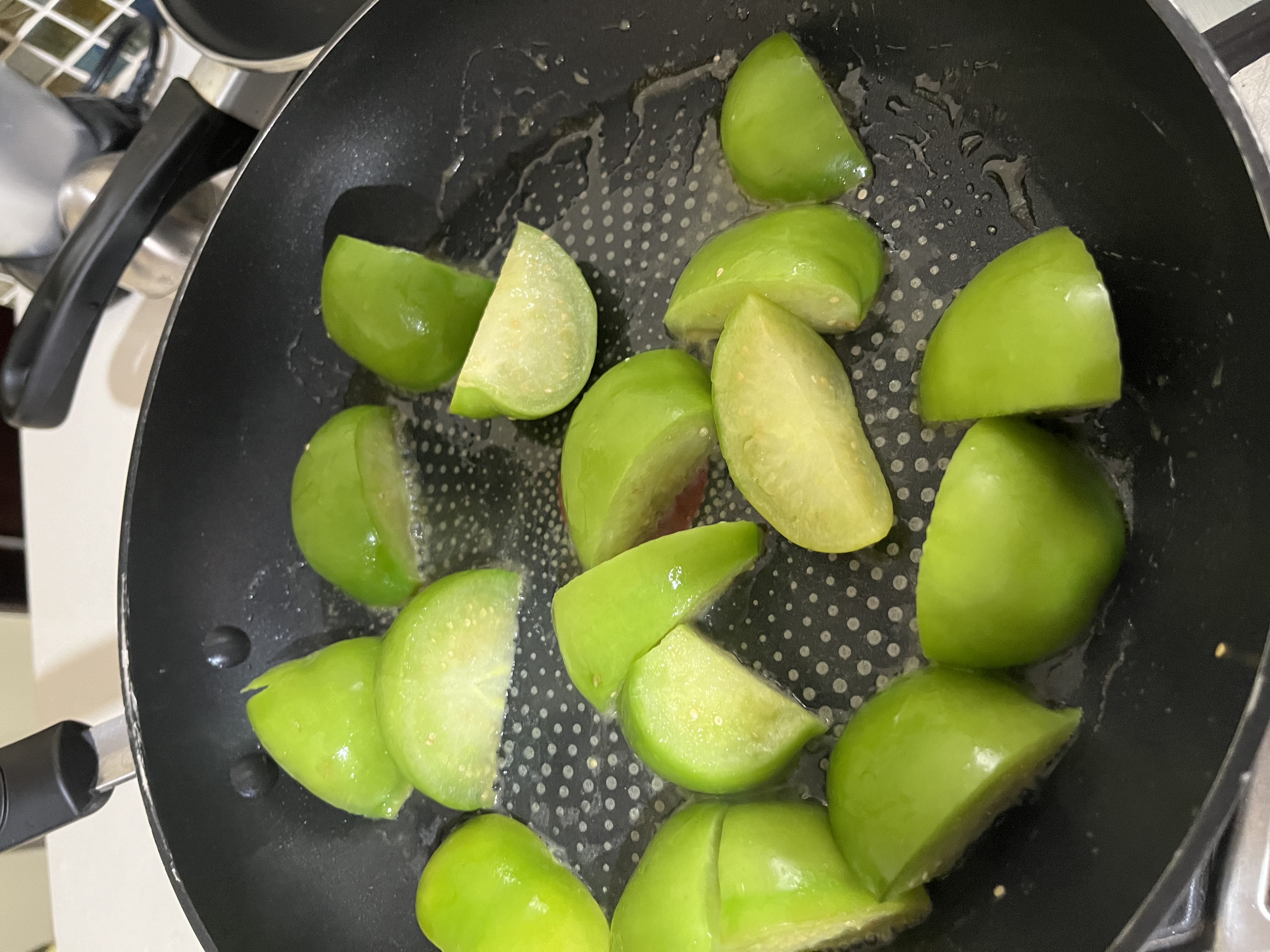 Tomatoes cooking Fresh green tomatoes sizzling in a pan of butter. One of the first steps to making salsa verde.